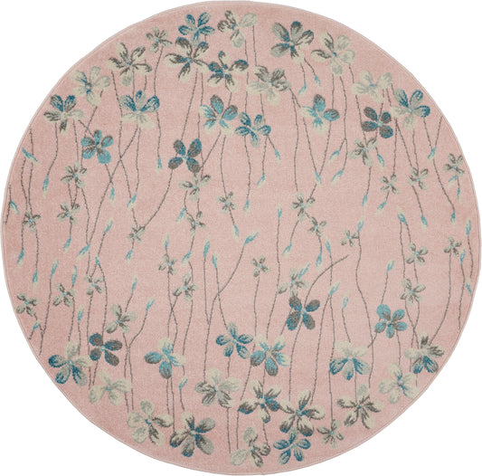 Round pink tufted rug with blue-green floral vines and small blossoms.