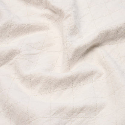 Cream fabric with a subtle tan grid pattern and soft, natural wrinkles.