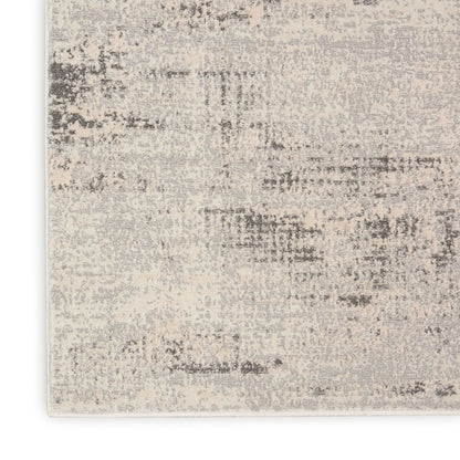Neutral beige and gray abstract area rug with a distressed patchwork pattern and soft, textured finish.