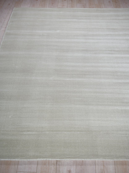 Soft beige rectangular rug with subtle tonal stripes; flat-weave, low-pile for living room.