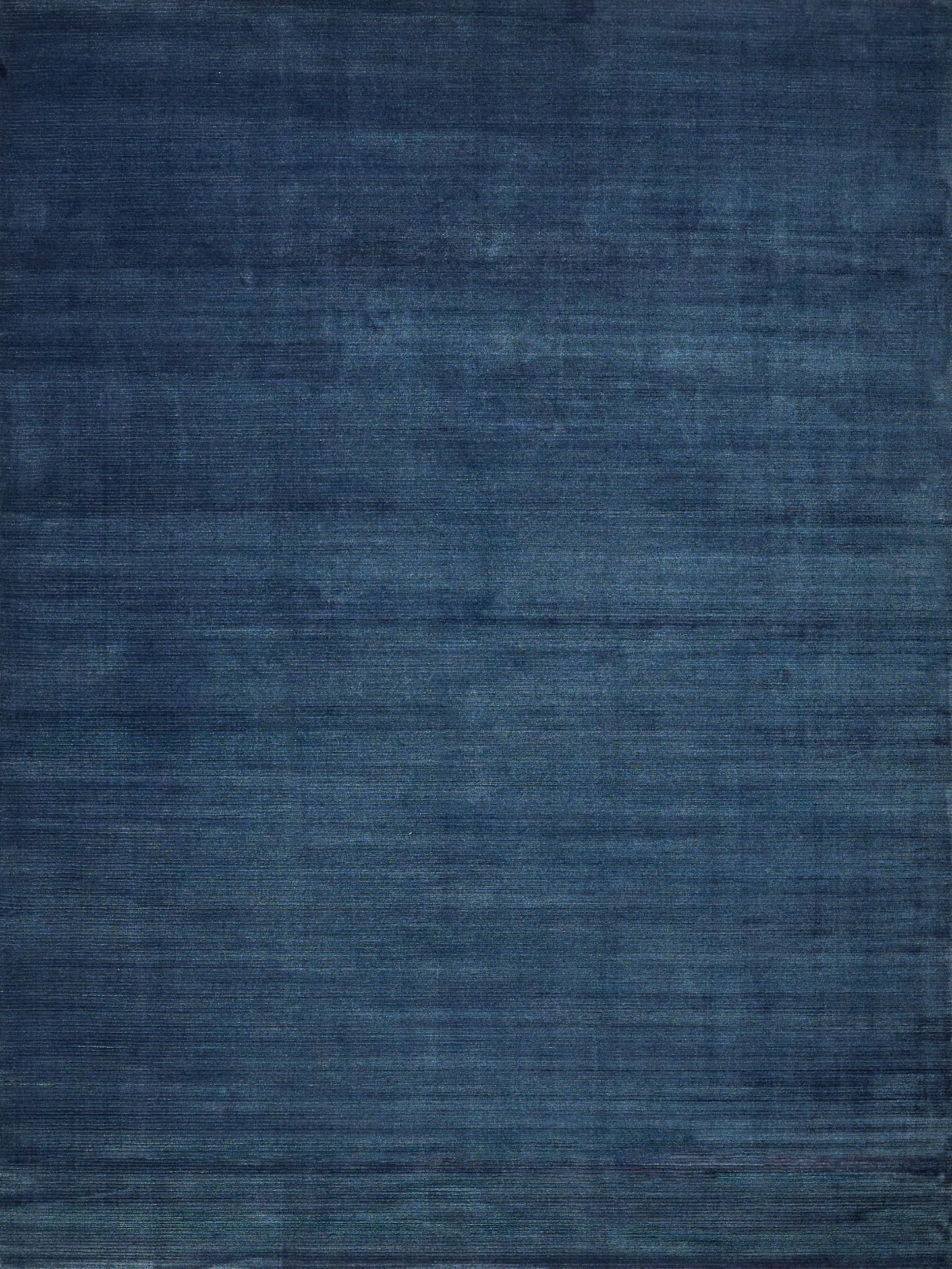 Blue textured area rug with navy and indigo tones and subtle distressed weave.