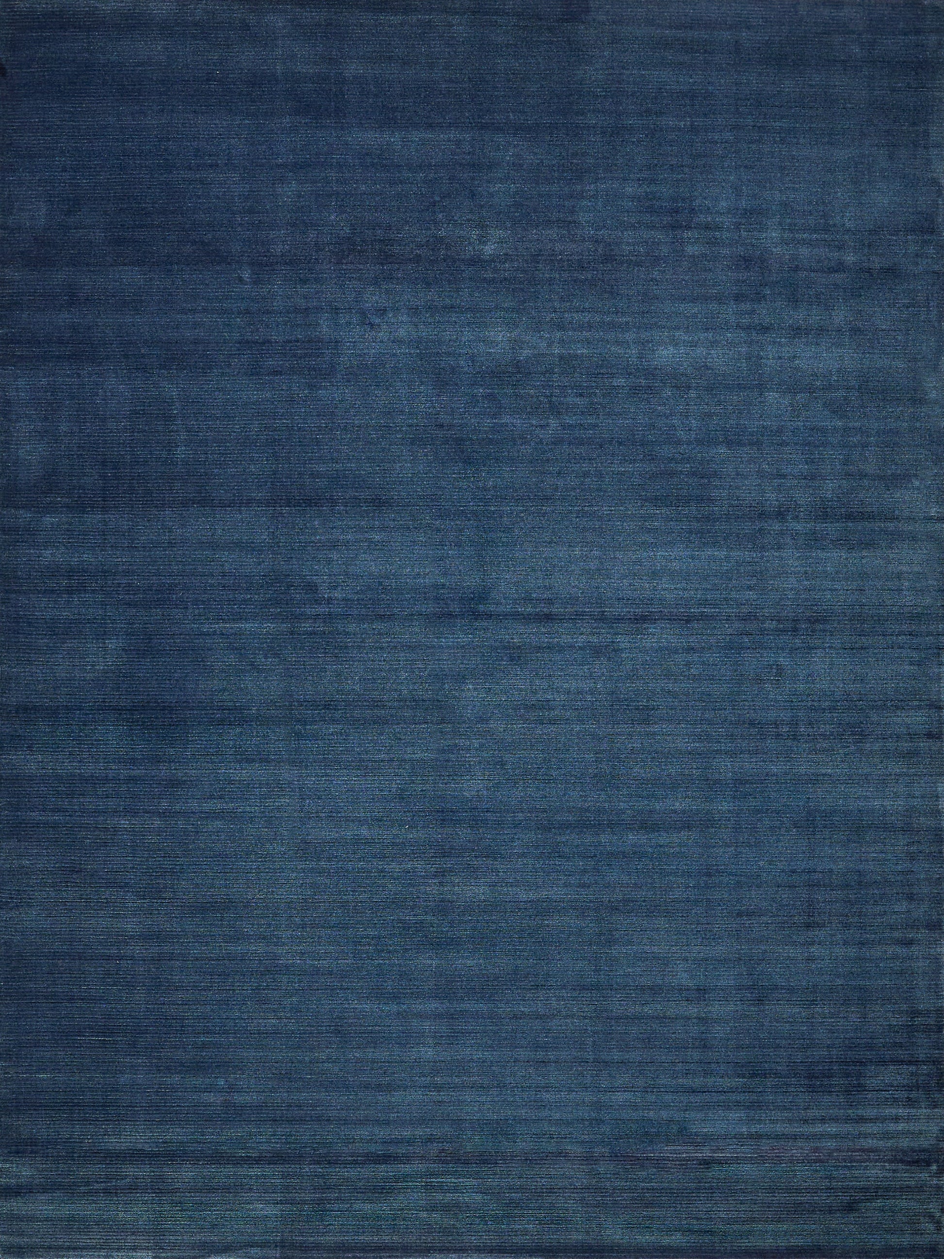 Blue textured area rug with navy and indigo tones and subtle distressed weave.