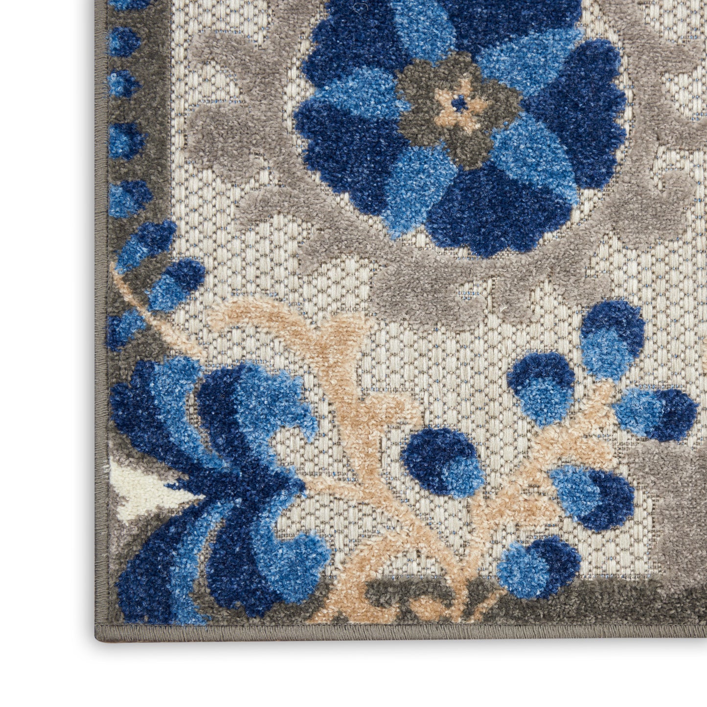 Rectangular area rug featuring bold blue flowers on taupe-beige background with a textured plush pile.