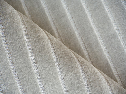 Beige rug with a subtle silver striped pattern and soft pile; hand loomed indoor rug.