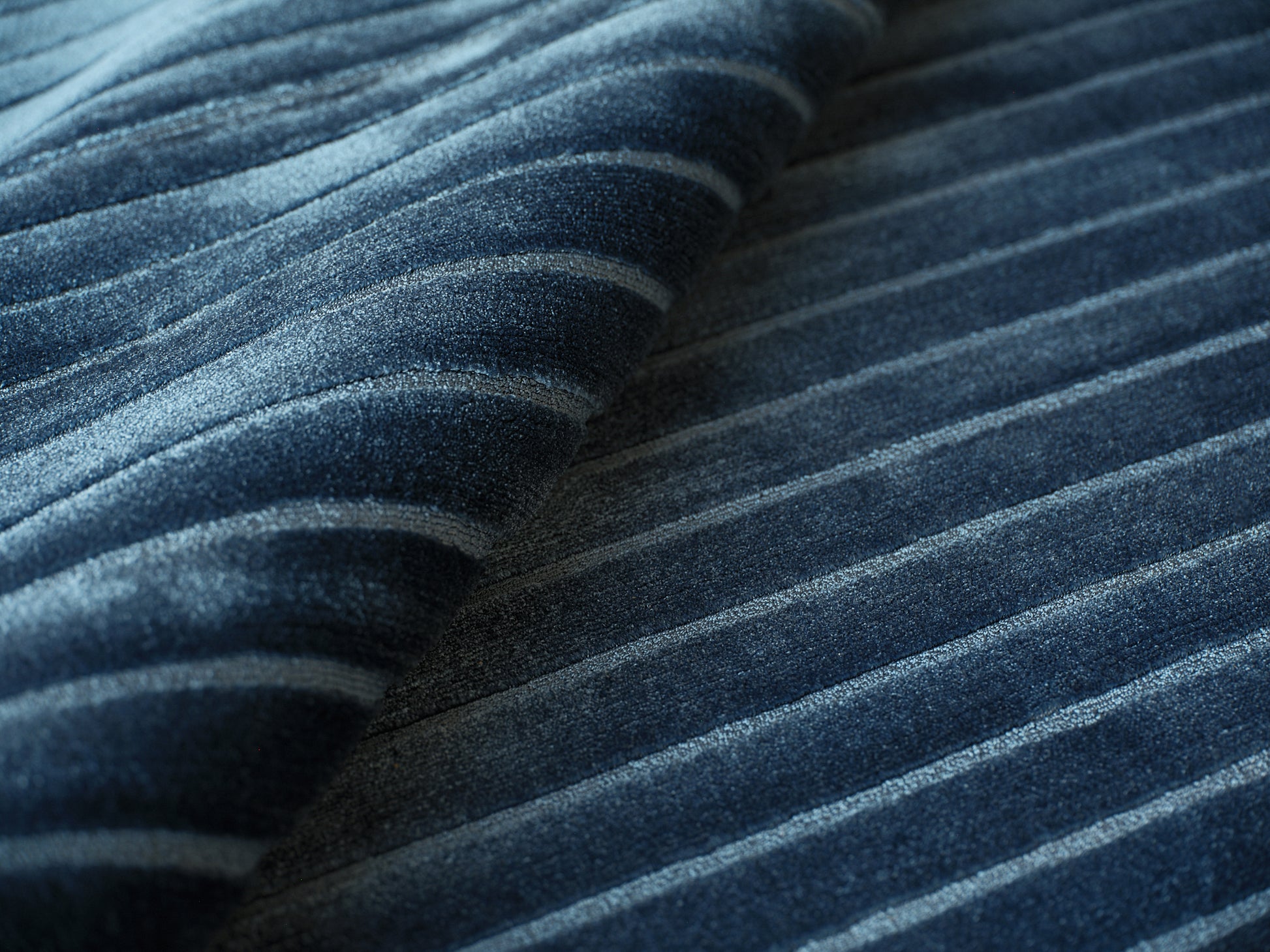 Close-up of a dark blue striped rug with light blue bands; hand-loomed indoor rug with plush, textured pile, 2' x 3'.