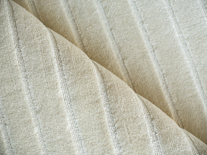 Beige hand-loomed rug with subtle vertical stripes; indoor use.