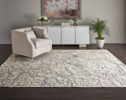 Beige tufted armchair beside cream patterned rug, with a textured white sideboard, plant, flowers, and bold floral art.