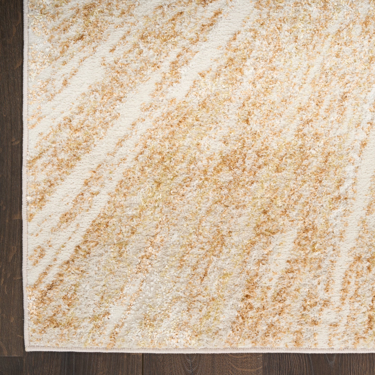 Rectangular beige-ivory flatweave rug with abstract tan streaks on dark wood floor.