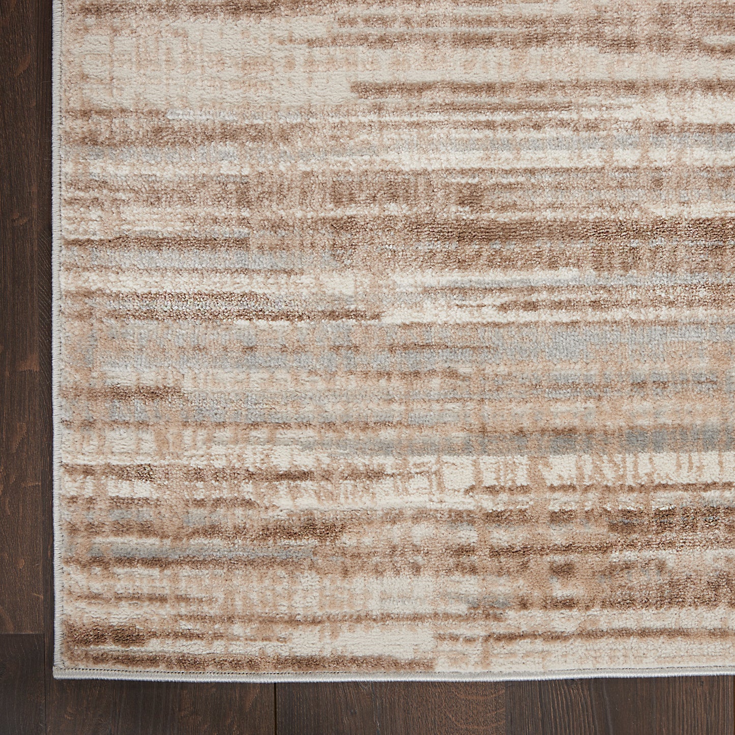Beige and tan abstract runner rug with horizontal brushstroke pattern on dark wooden floor.