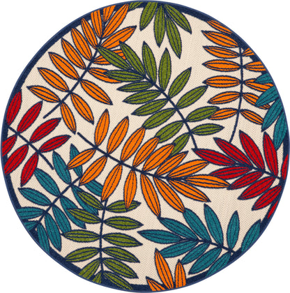 Round decorative rug with multicolored leaf pattern in orange, red, green & teal on beige with navy border.