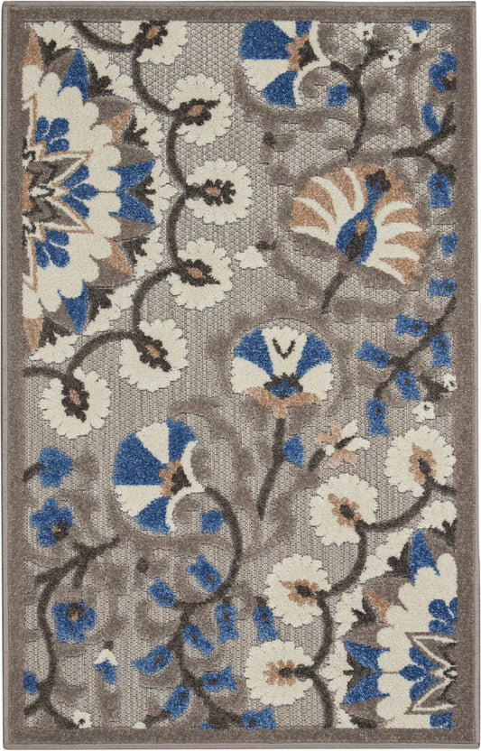Rectangular beige-brown area rug with cream flowers & blue accents, dark vines in a floral motif; woven texture.