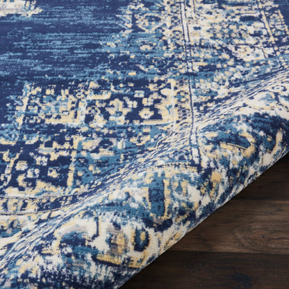 Blue and ivory distressed oriental rug with intricate geometric pattern, measuring 3' x 5', partially rolled on a dark wood floor.