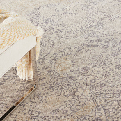 Beige-gray Persian-pattern rug with ornate florals; woven texture, shown with a cream throw on a chrome-framed chair.