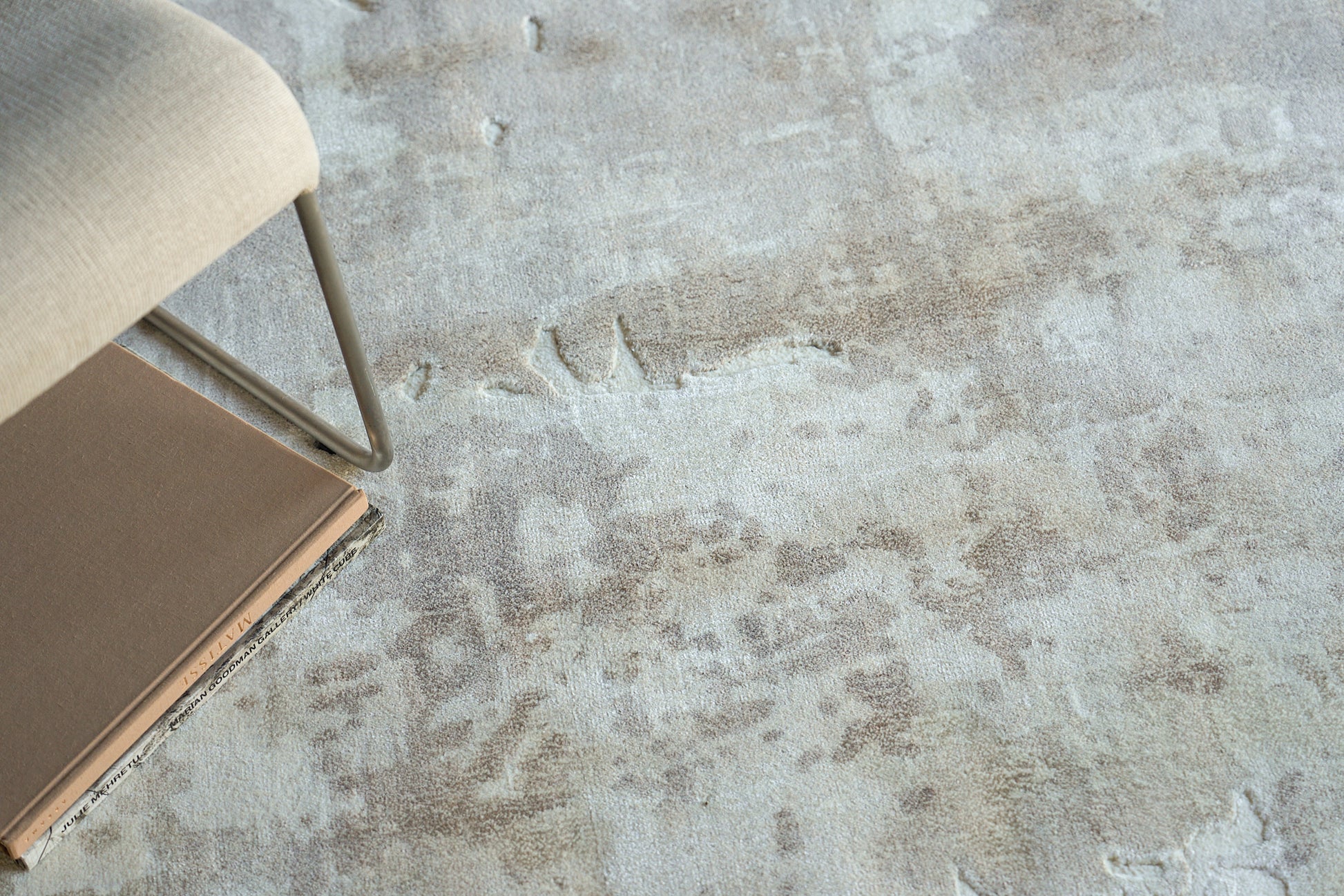 Beige indoor hand loomed rug on a textured floor