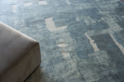 Blue abstract patchwork area rug with lighter beige patches, distressed pattern, soft pile.