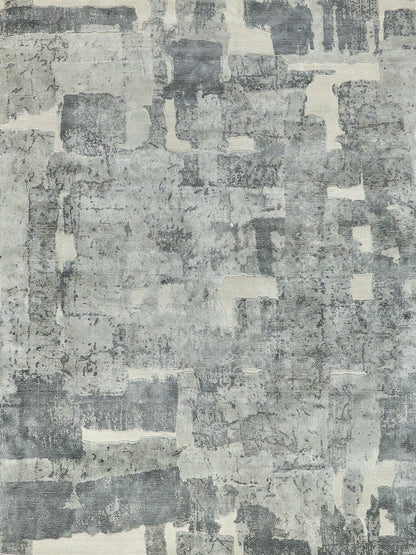 Rectangular abstract distressed patchwork rug in gray-blue and ivory tones for living room decor.