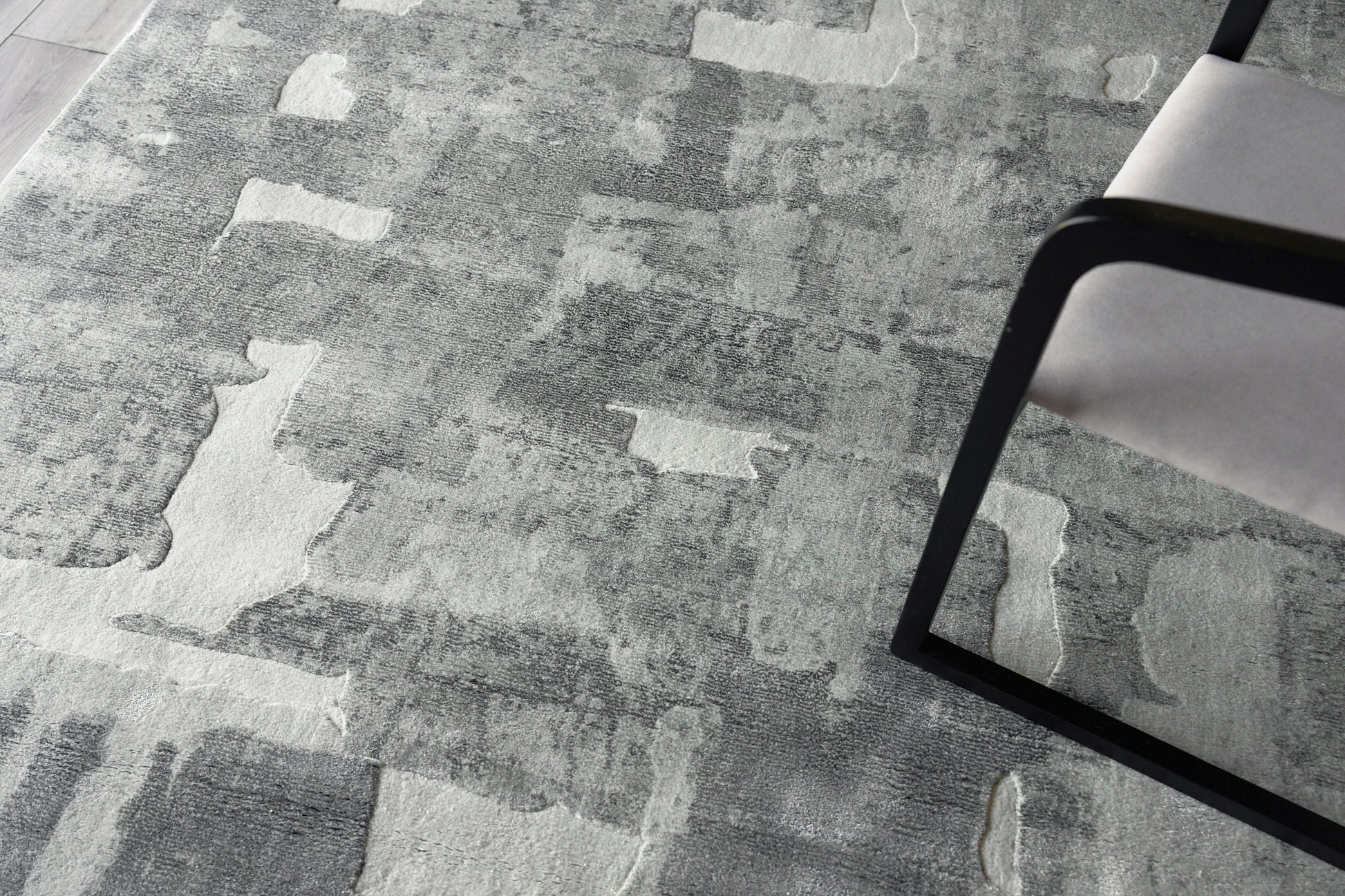 Gray abstract area rug with patchwork pattern in light and dark gray tones.