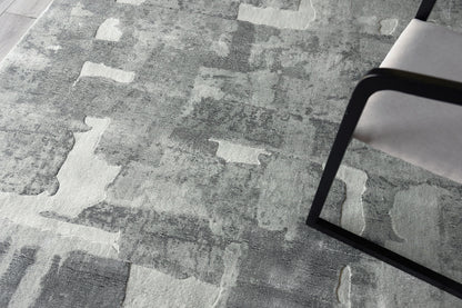 Gray abstract area rug with patchwork pattern in light and dark gray tones.