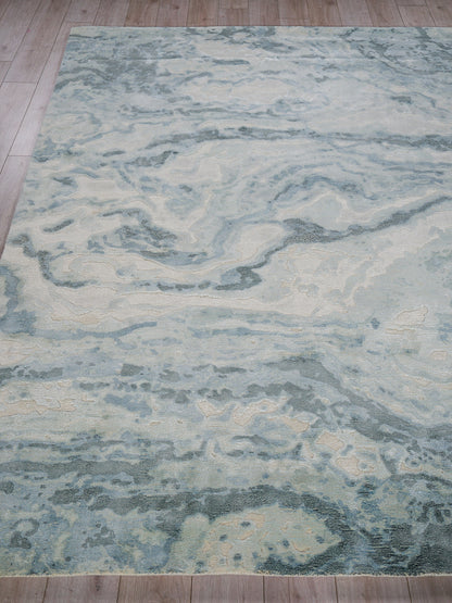 Large rectangular rug with pale blue, ivory and gray marble-like pattern; modern abstract style on wood floor.