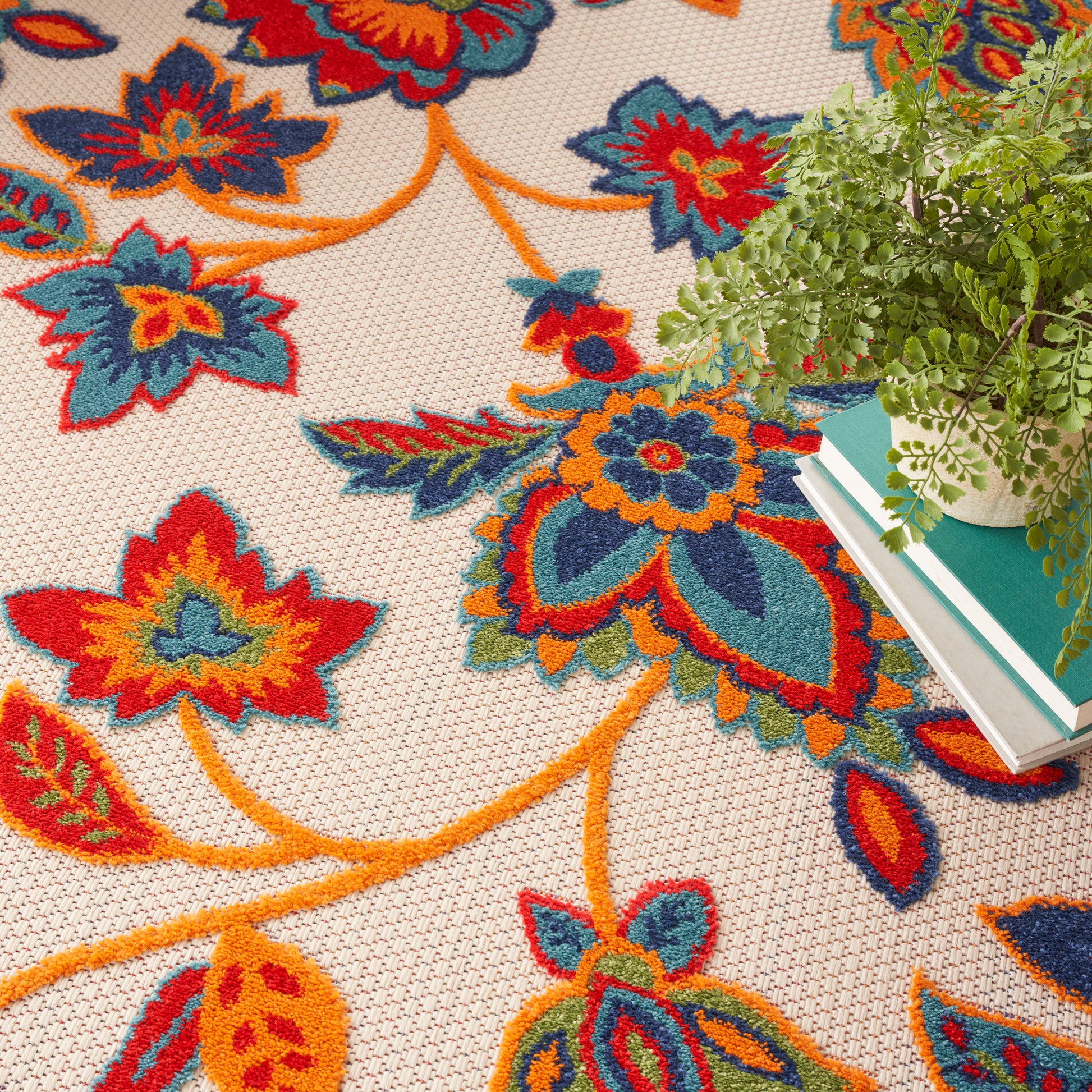 Vibrant floral woven area rug with orange, teal, red flowers on beige background; boho-style floor decor.
