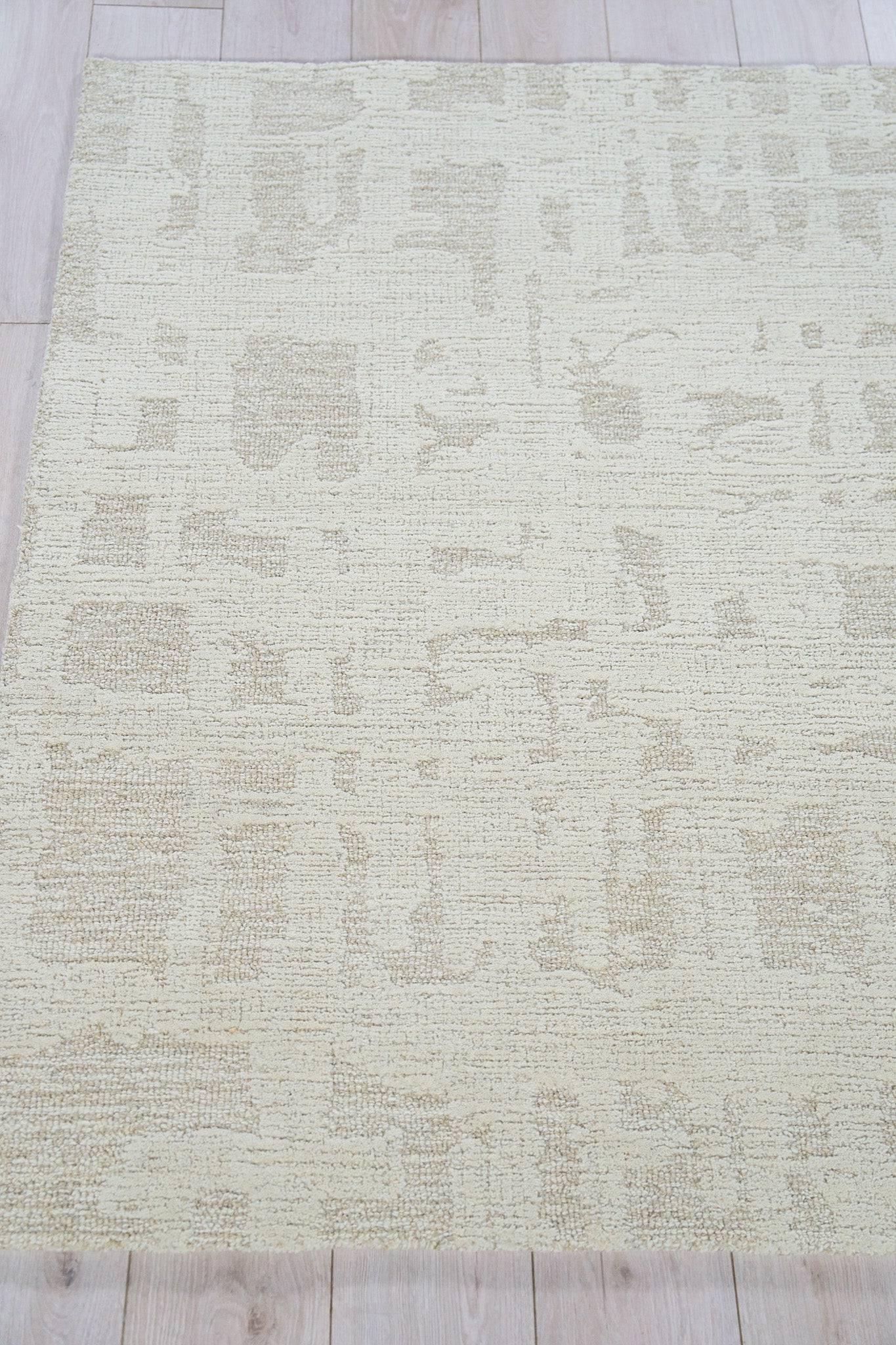 Beige rectangular rug with a soft, textured pile and subtle cream abstract pattern; neutral, modern decor.