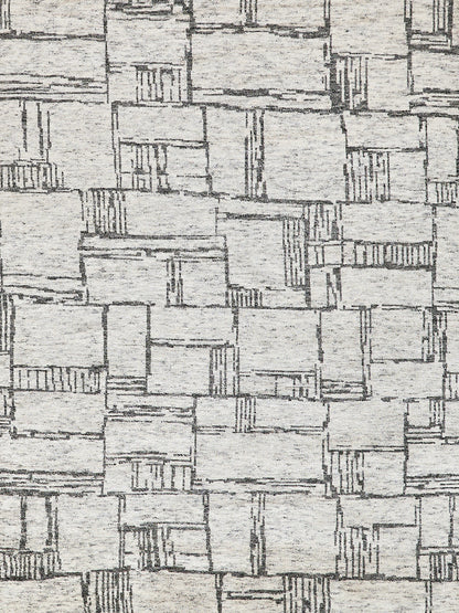 Beige woven rug with gray rectangular patchwork blocks and subtle textured lines; modern geometric pattern.