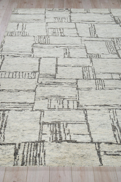 Light beige geometric area rug with dark gray rectangular blocks; modern low-pile, abstract patchwork design.