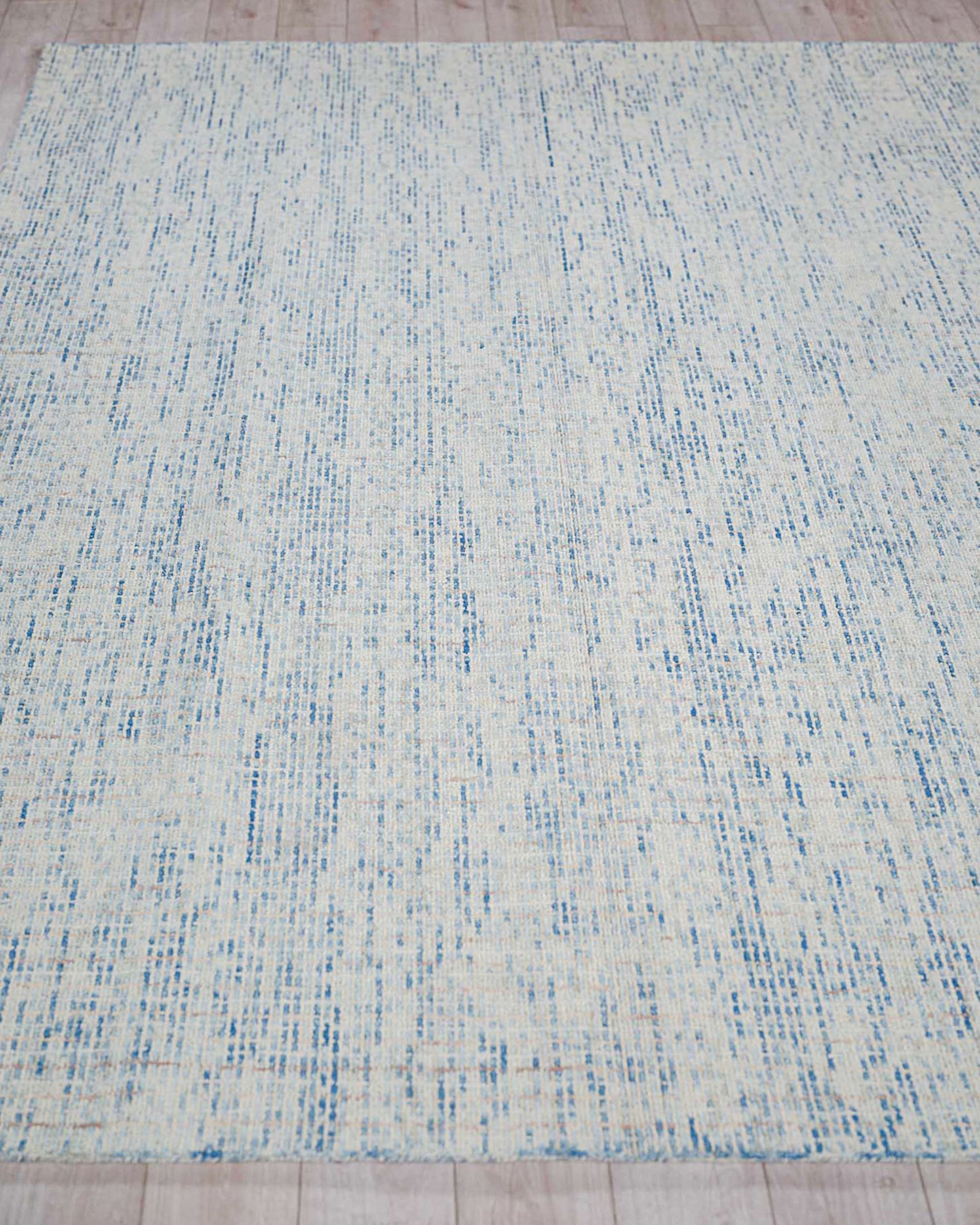 Rectangular cream rug with pale blue specks and streaks, distressed pattern; hand-tufted indoor rug.