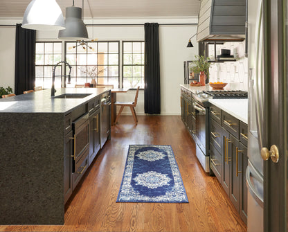 Vintage 8' navy-toned runner rug on hardwood floors in a modern gray kitchen with dark cabinetry, brass pulls, granite island and stainless appliances.