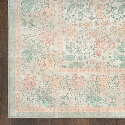 Pastel floral area rug with peach, pink, teal flowers and green leaves, bordered in peach and light blue, on dark wood floor.