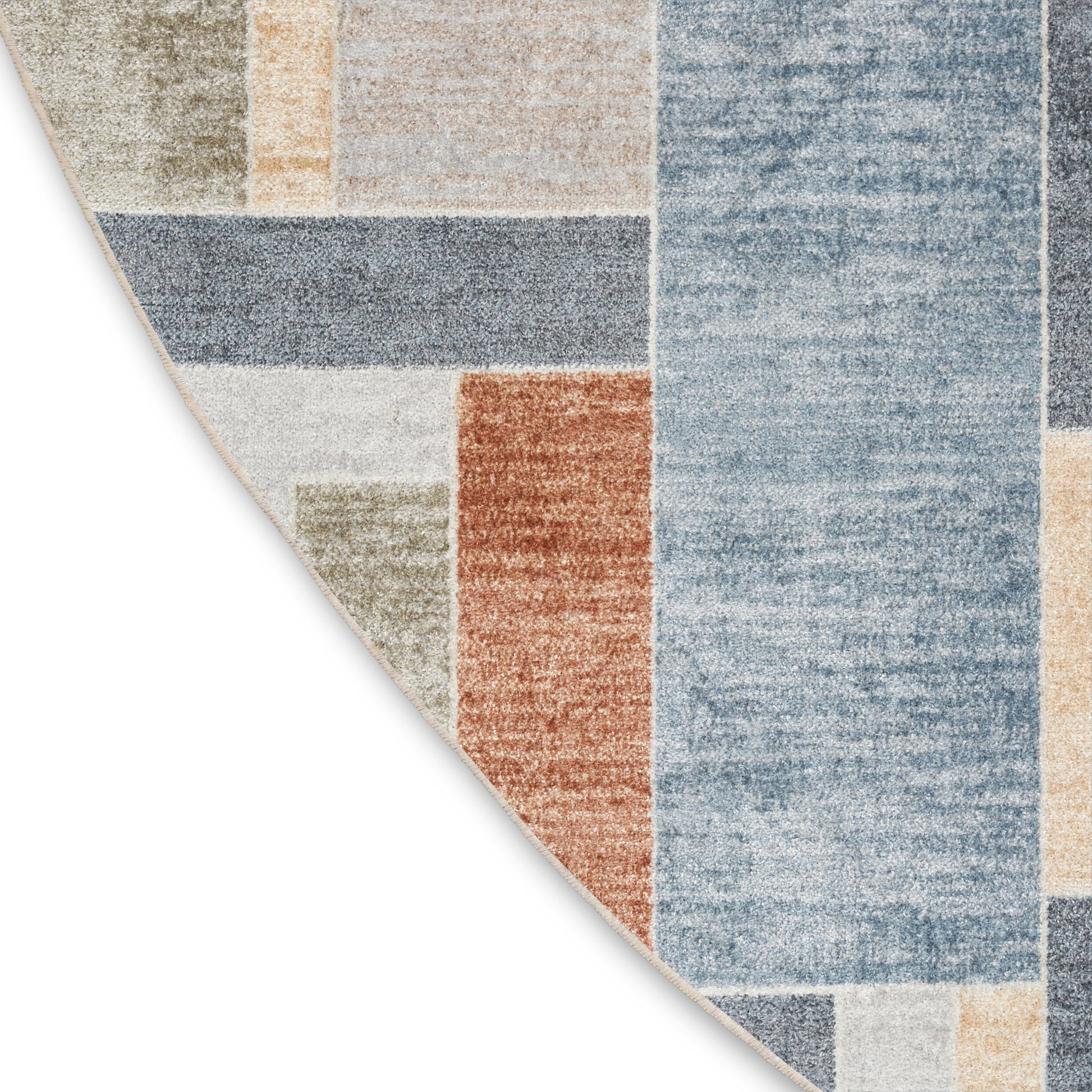 Round patchwork area rug with geometric color blocks in blue, beige, rust and olive hues.