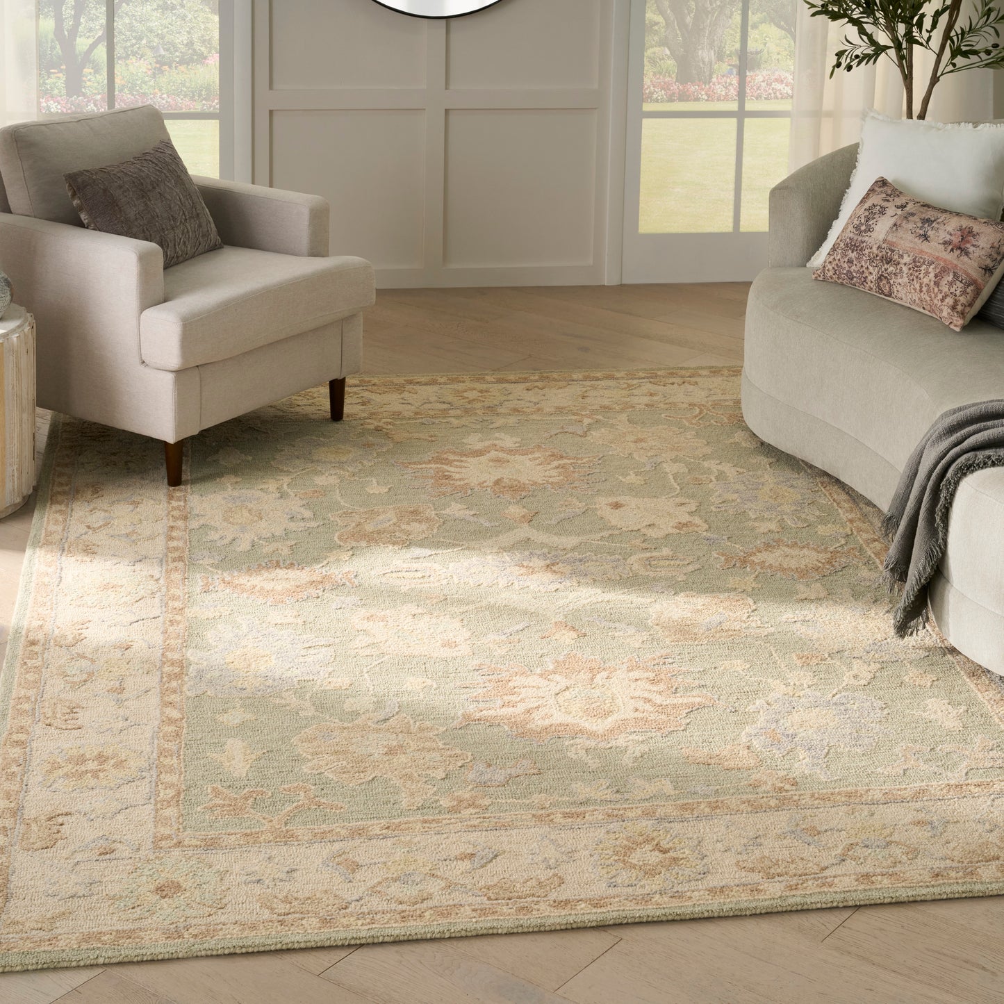 Soft beige vintage oriental area rug with blue accents in a bright living room, beige upholstered seating and throw pillows.