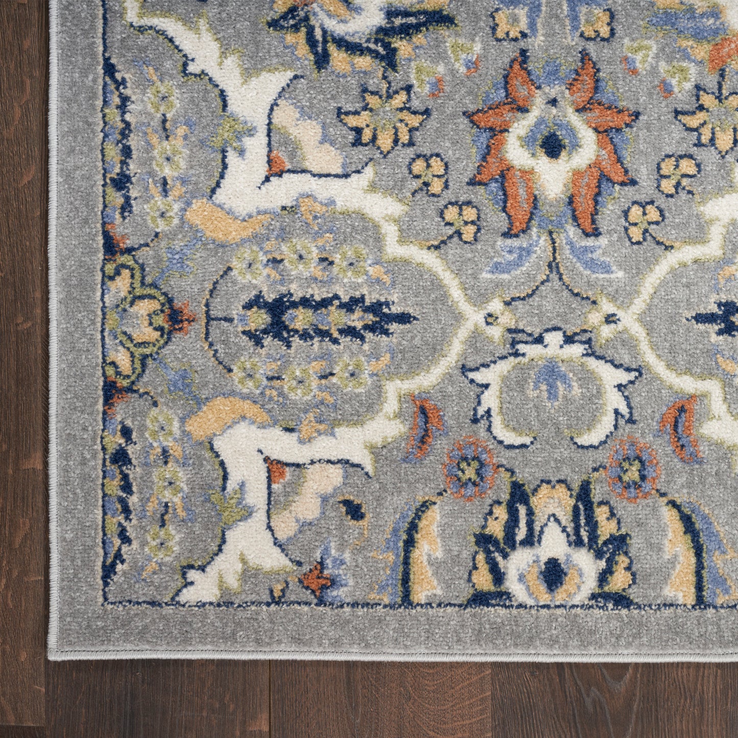 Grey Bohemian area rug with blue, ivory & orange floral medallion pattern on dark wood floor, 4' x 6'.