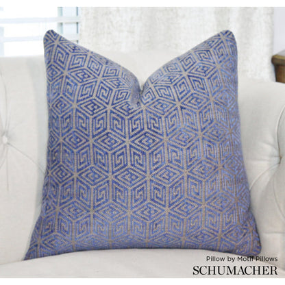 Blue and beige geometric patterned woven throw pillow on a cream sofa.