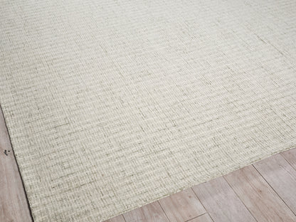 Beige textured area rug with subtle woven pattern over light wood floor.