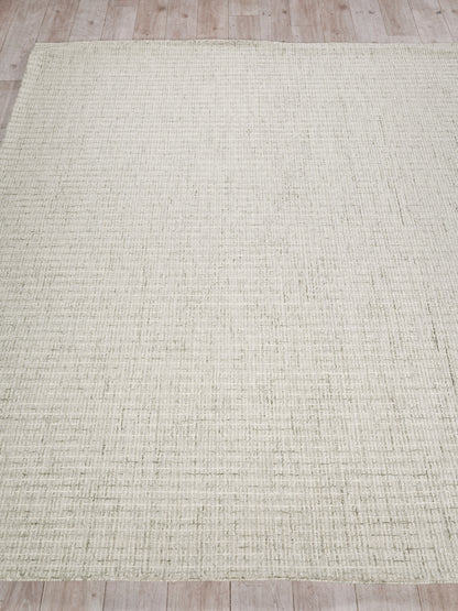 Rectangular beige hand tufted rug with a subtle grid texture on a light wooden floor.