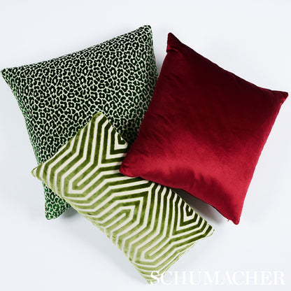 Three square decorative pillows: green leopard print, lime geometric pattern, and solid red velvet.