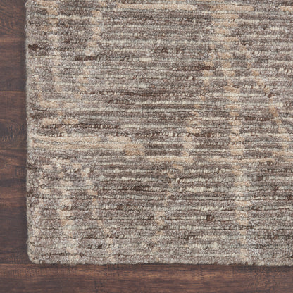 Brown and beige textured rug with subtle stripe pattern on dark wooden floor.