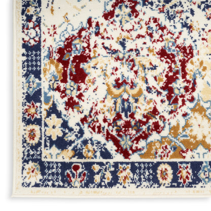 Vintage-style rug corner with ivory field, red, blue and gold florals; navy border and cream fringe.