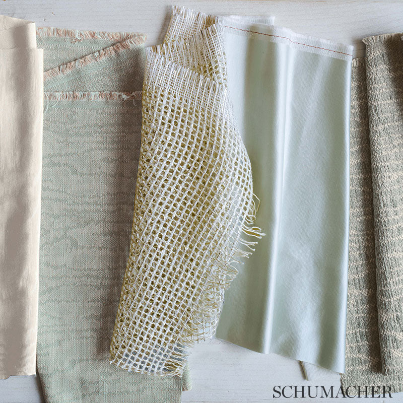 Assorted fabric swatches in pale beige, mint and cream with netting and woven textures.