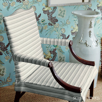 Gray striped upholstered armchair with dark wood curved arms in a vintage living room setting