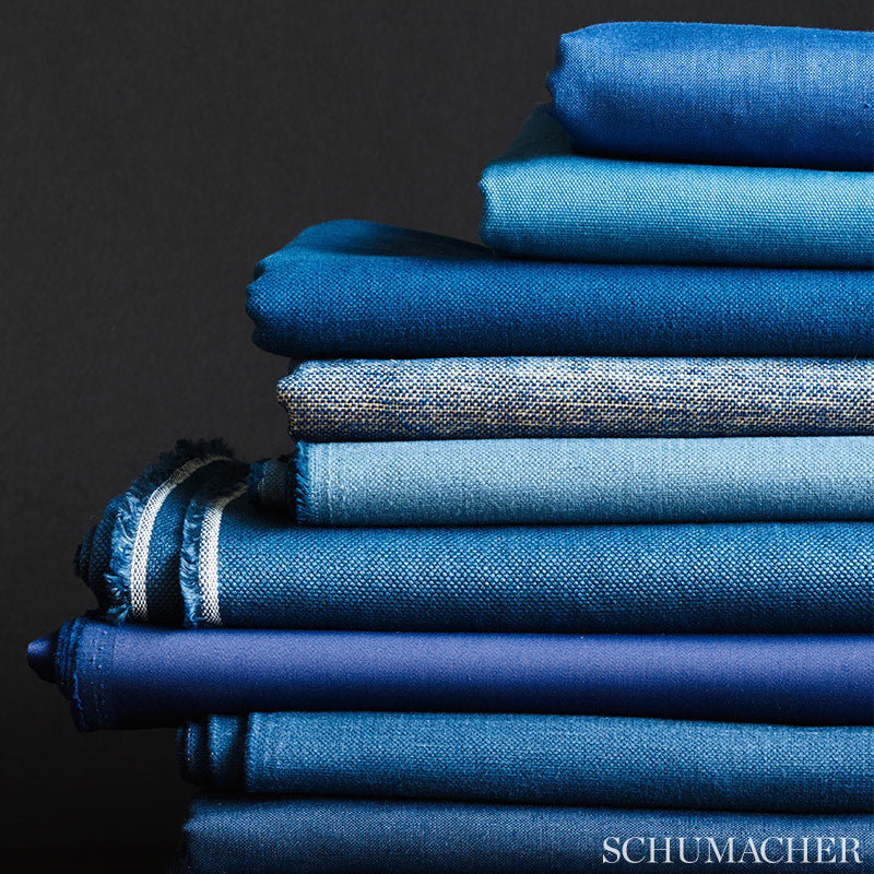 Pile of blue fabrics in varying denim-like textures and shades, for sewing or upholstery.