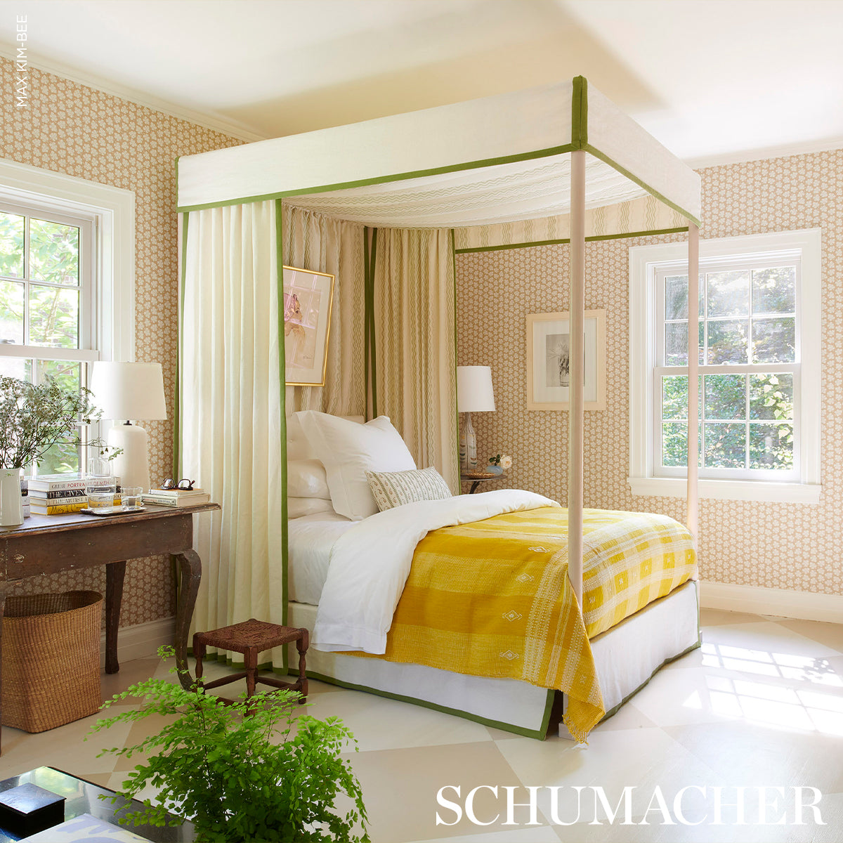 Cream four-poster bed with green trim and sheer curtains, grass-print bedding, vintage room with wallpaper and plants.