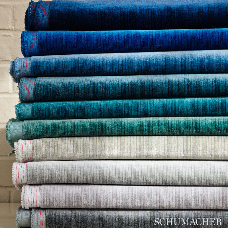 Stack of folded velvet-woven fabrics in Mercury gray featuring an antique strie pattern and textured striped weave