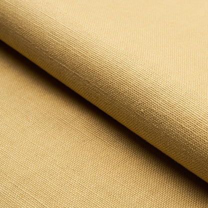 Beige woven fabric roll with visible texture and folded edge; neutral upholstery or garment textile.