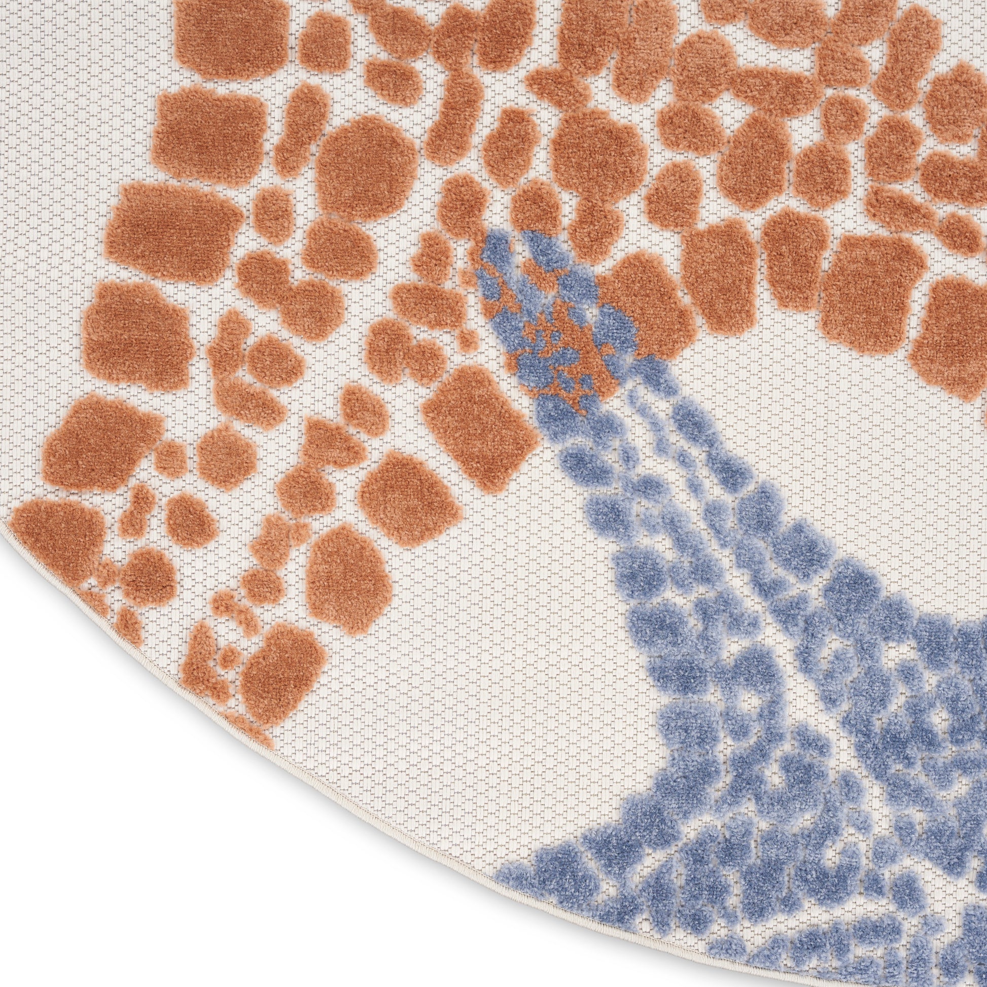 Round rug with orange-brown circular spots and a blue curved speckled motif; modern decorative textile.