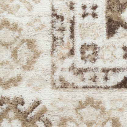 Close-up of a cream and beige shag rug with light brown geometric border and plush texture.