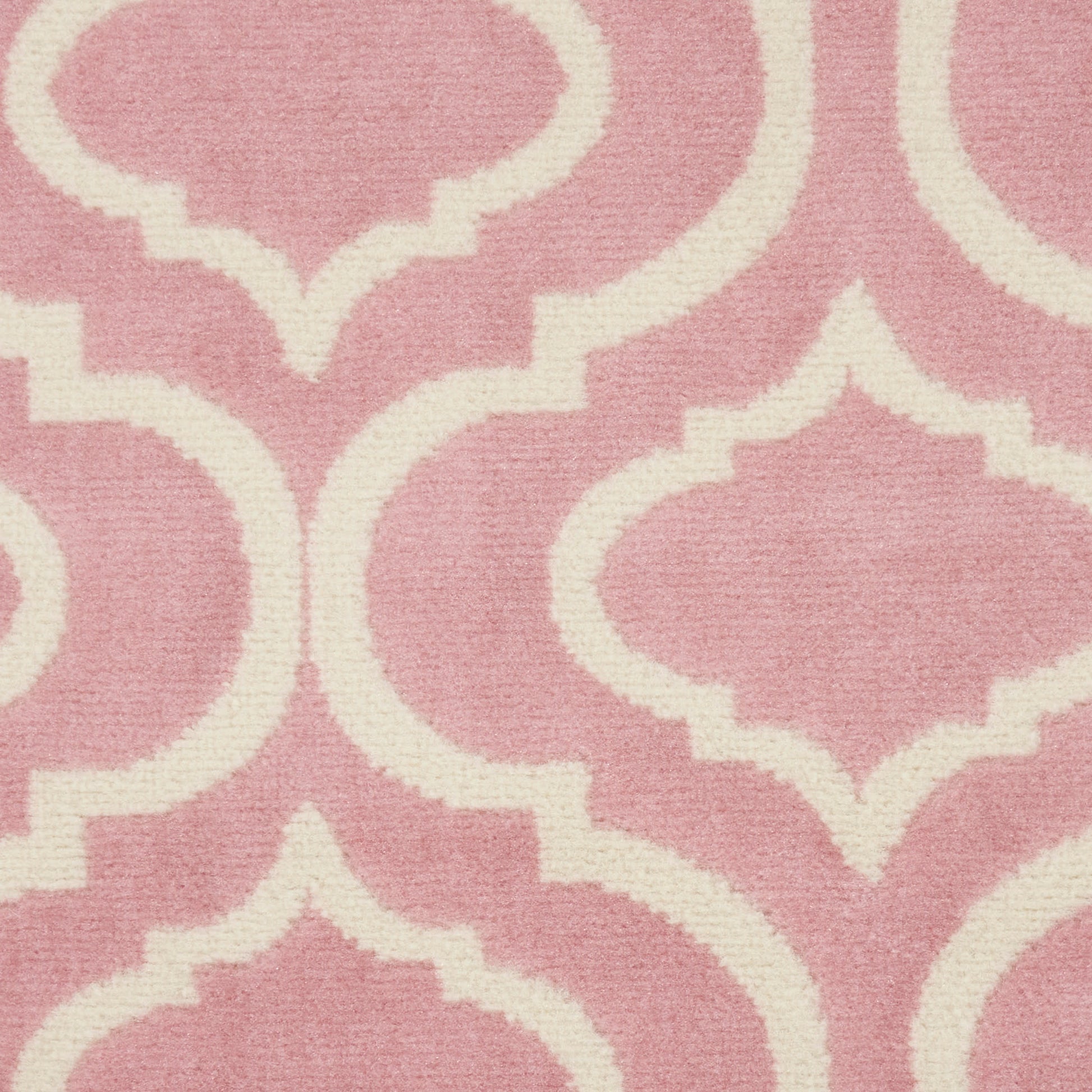Dusty pink rug featuring a cream and white Moroccan trellis quatrefoil pattern.