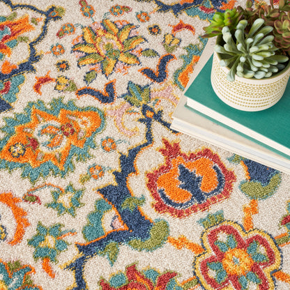Colorful Persian-style rug with orange, teal, blue floral motifs; stack of books topped by a succulent in a dotted white pot.