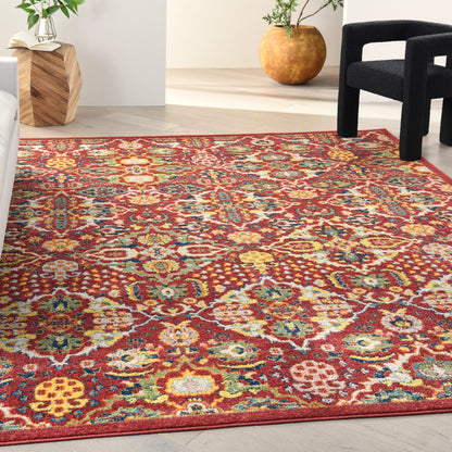 Red Persian-style rug with multicolor floral motifs on a light wood floor.